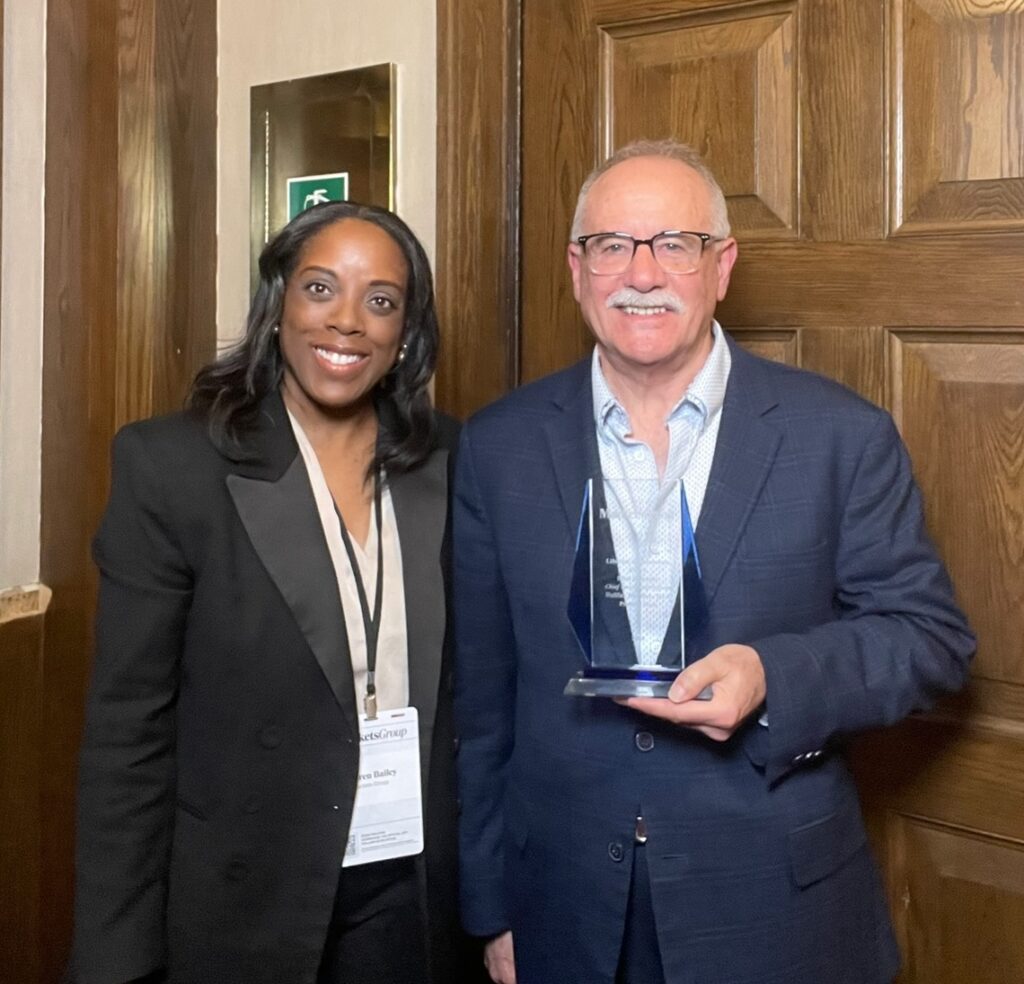 Markets Group Deputy Editor Lauren Bailey stands with Blair Richards, who holds his 2026 Lifetime Achievement Award at the Canada Investors Retreat.
